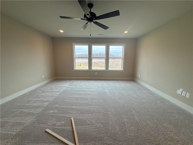 carpeted spare room with ceiling fan