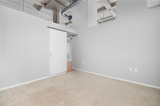 carpeted spare room with a towering ceiling