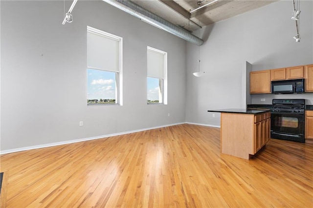 kitchen with range, light hardwood / wood-style floors, and rail lighting