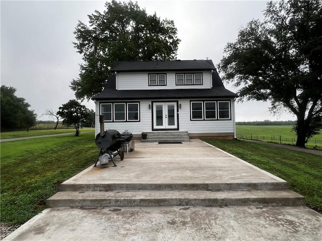 view of front facade featuring french doors, a patio area, and a front lawn