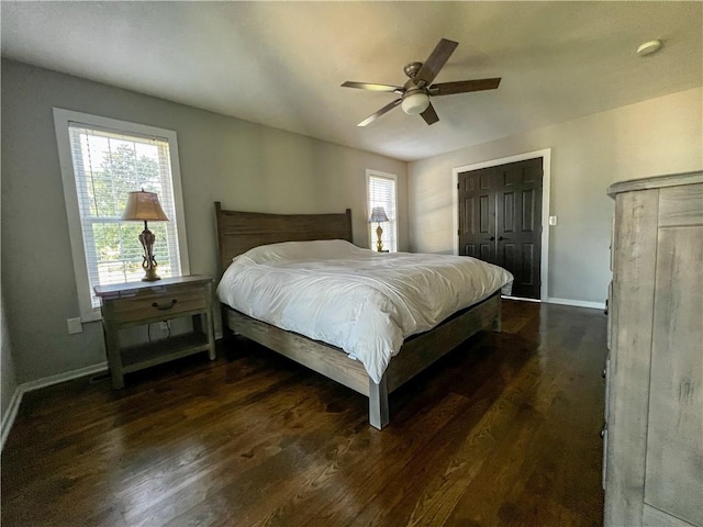 bedroom with dark wood-type flooring, ceiling fan, and multiple windows