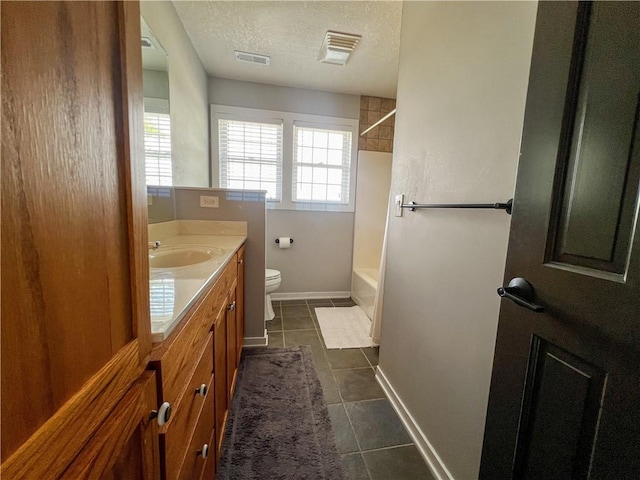 full bathroom featuring tile patterned flooring, vanity, toilet, a textured ceiling, and washtub / shower combination