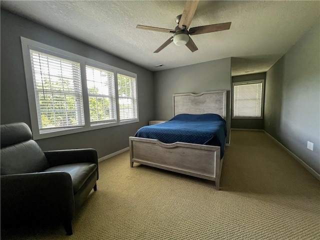 carpeted bedroom with ceiling fan and a textured ceiling