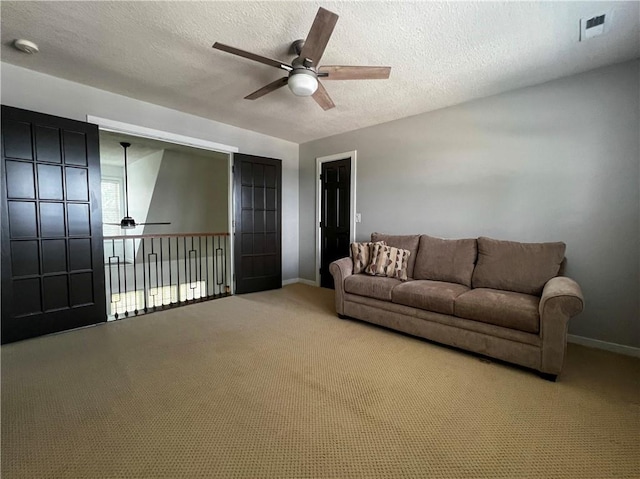 carpeted living room with a textured ceiling and ceiling fan