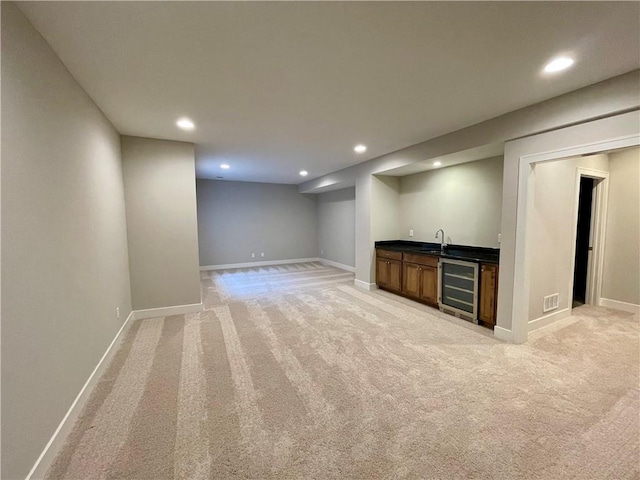 interior space featuring wine cooler, light carpet, and bar