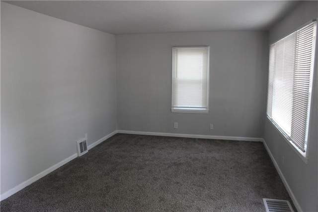 unfurnished room featuring dark colored carpet