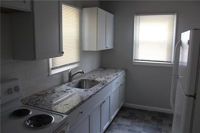 kitchen with sink, white cabinetry, white appliances, a healthy amount of sunlight, and decorative backsplash