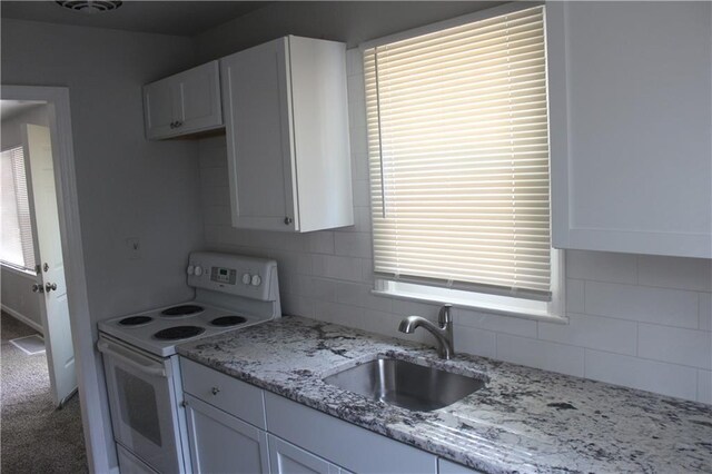 kitchen with sink, plenty of natural light, carpet flooring, white cabinets, and white electric stove