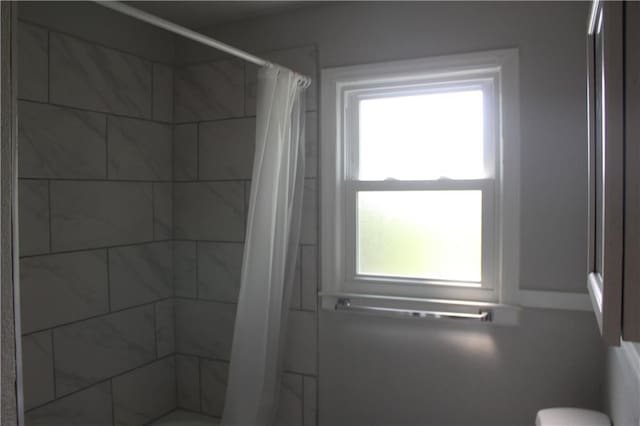 bathroom featuring toilet and a shower with shower curtain