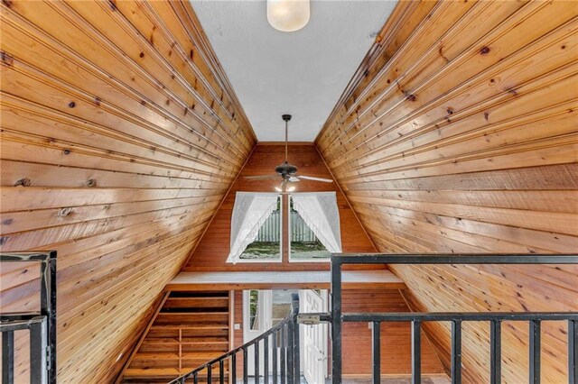 interior space with wood walls, wooden ceiling, and ceiling fan