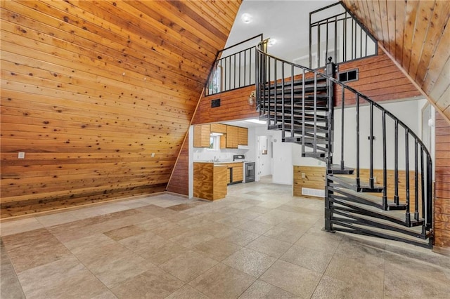 unfurnished living room featuring wood ceiling, tile patterned floors, wooden walls, and a high ceiling