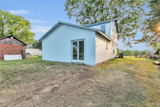 rear view of house featuring a yard and central AC