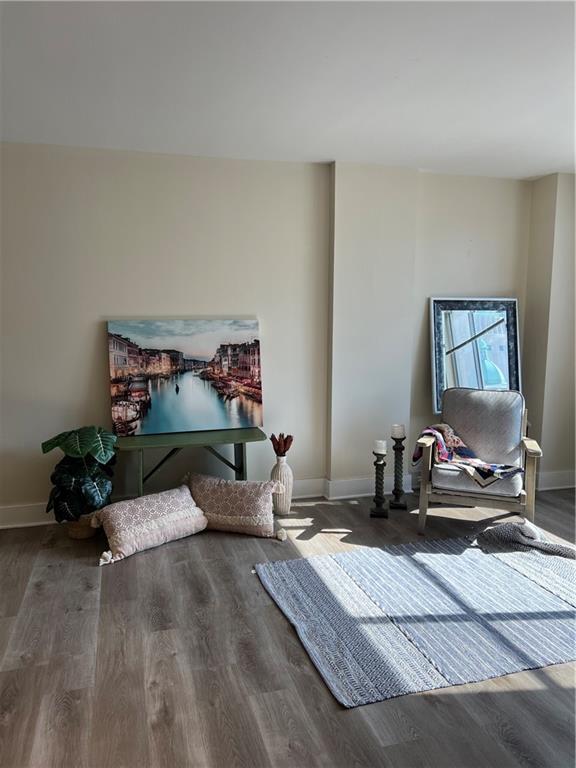 sitting room with baseboards and wood finished floors