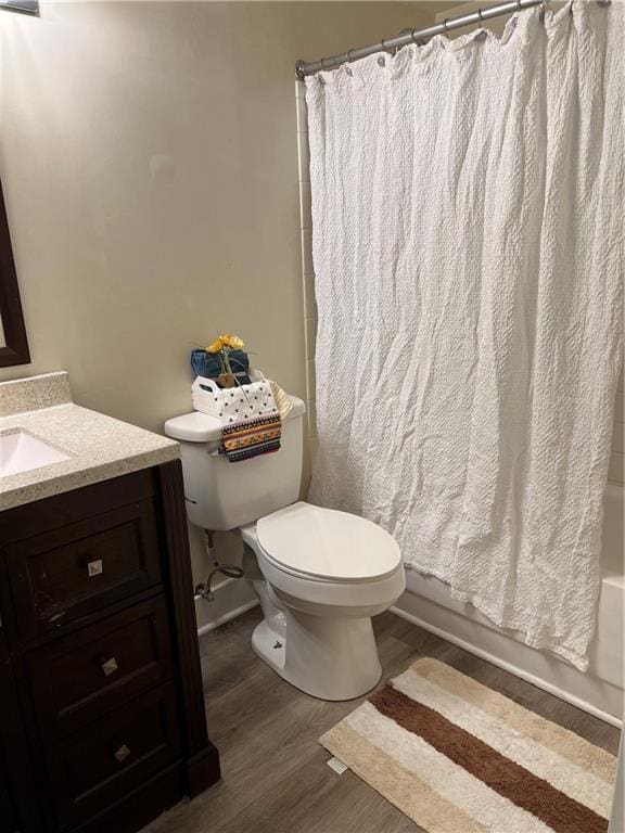 bathroom featuring shower / bath combo, vanity, toilet, and wood finished floors