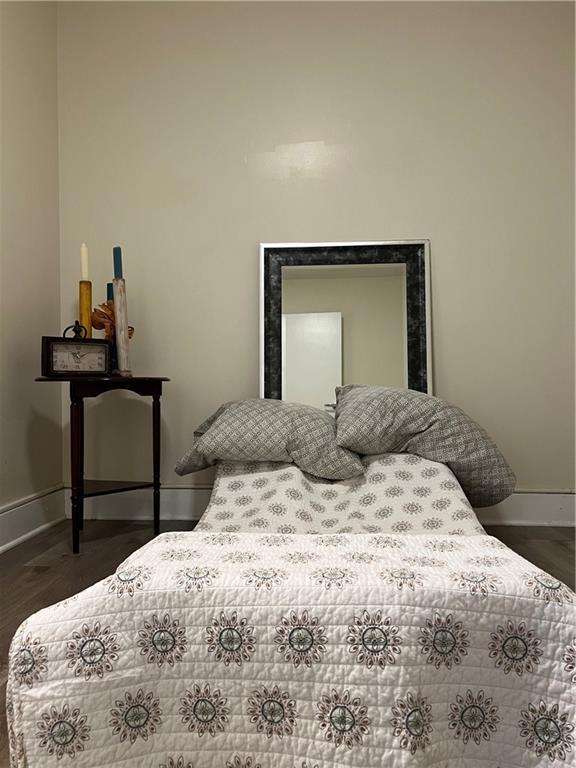 bedroom with dark wood-style floors and baseboards