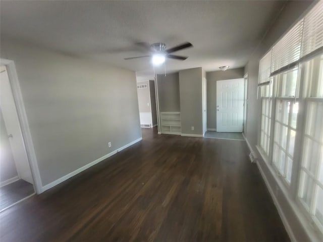 empty room featuring ceiling fan and dark hardwood / wood-style flooring