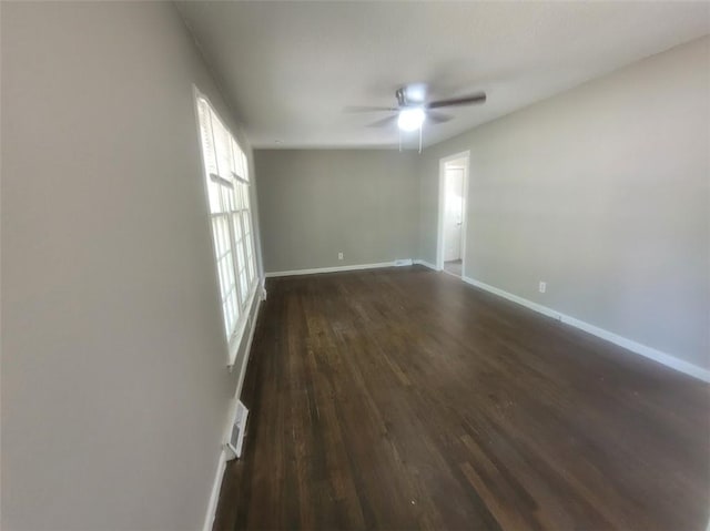 spare room with dark wood-type flooring and ceiling fan