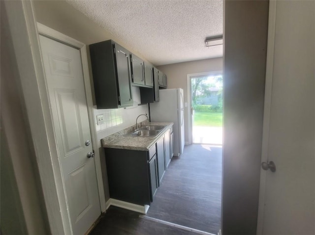 kitchen featuring gray cabinets, sink, decorative backsplash, white refrigerator, and a textured ceiling