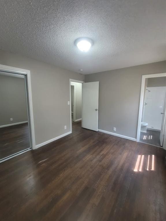 interior space with a textured ceiling and dark hardwood / wood-style flooring