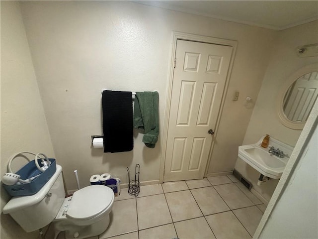 bathroom featuring crown molding, sink, tile patterned floors, and toilet