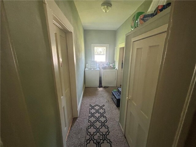 clothes washing area featuring light carpet and washing machine and clothes dryer