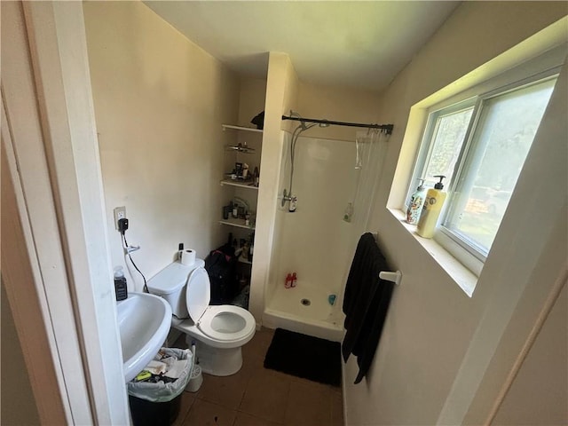 bathroom featuring toilet, sink, tile patterned floors, and a shower with shower curtain