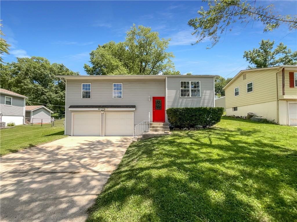 raised ranch with a garage and a front yard