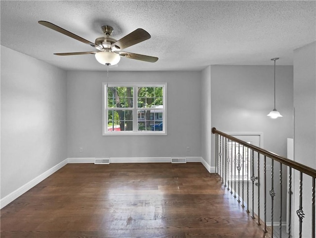 spare room with dark hardwood / wood-style flooring and a textured ceiling