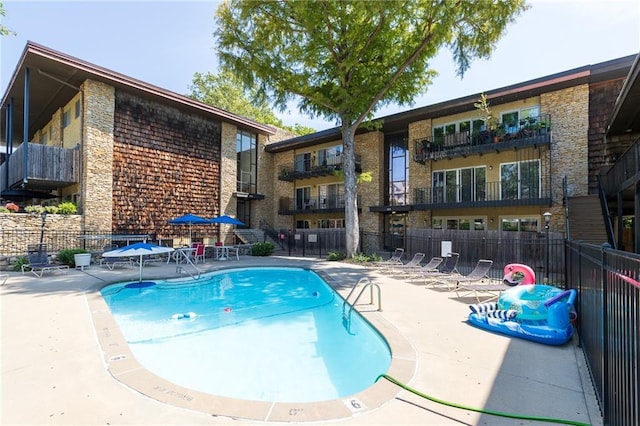 community pool featuring a patio area and fence