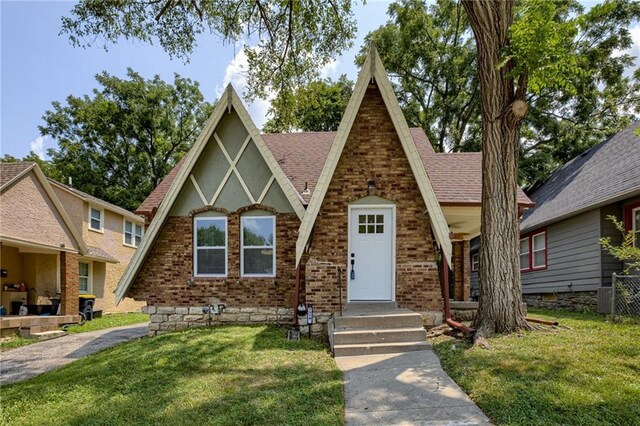 tudor-style house featuring a front yard