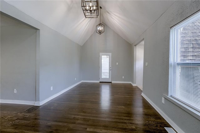 foyer entrance featuring vaulted ceiling, dark hardwood / wood-style floors, and a chandelier