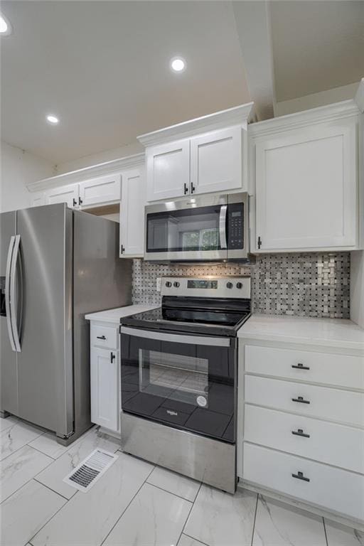 kitchen with decorative backsplash, stainless steel appliances, and white cabinets