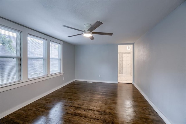 empty room with ceiling fan and dark hardwood / wood-style floors