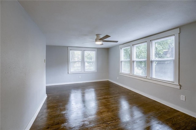 unfurnished room with dark wood-type flooring, ceiling fan, and plenty of natural light