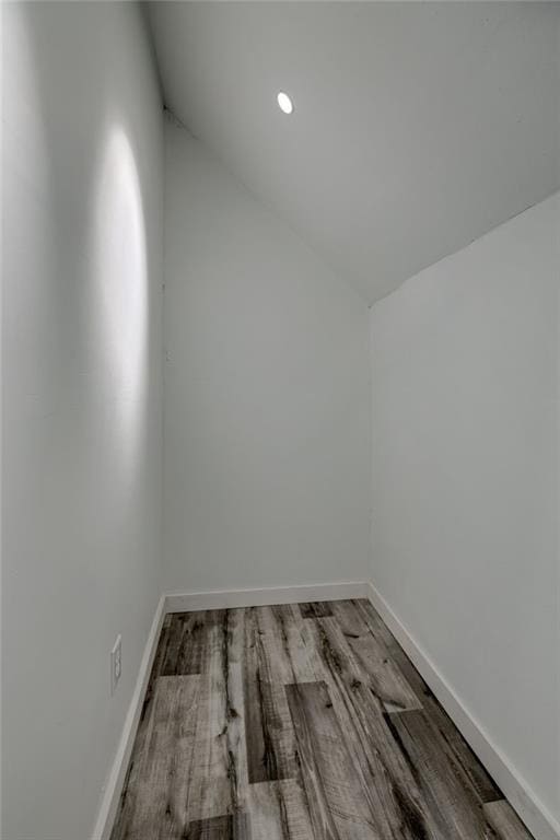 spare room featuring lofted ceiling and hardwood / wood-style floors