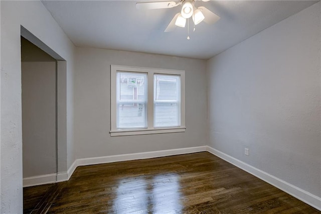 spare room with dark hardwood / wood-style floors and ceiling fan