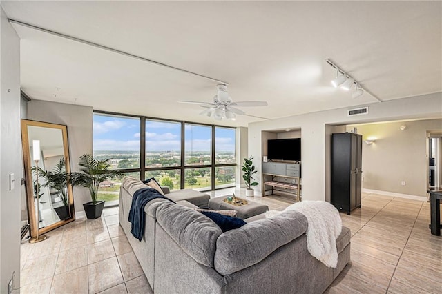 tiled living room featuring track lighting, ceiling fan, and floor to ceiling windows