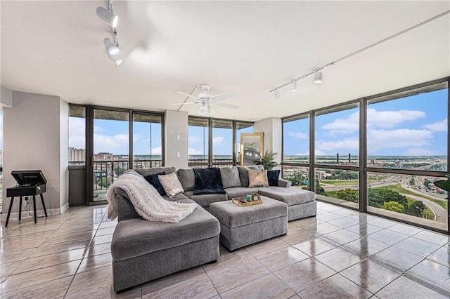 tiled living room featuring ceiling fan, track lighting, and floor to ceiling windows