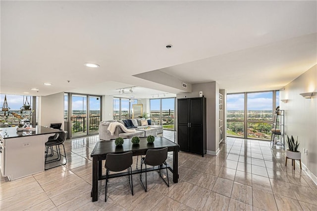 dining space with plenty of natural light, light tile patterned floors, and expansive windows