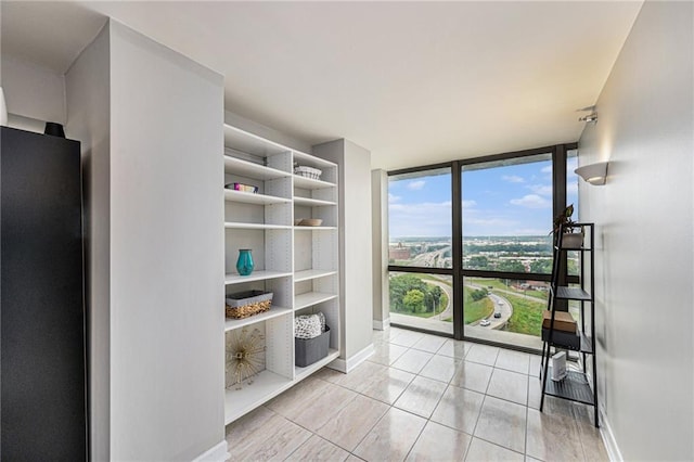 interior space with a wall of windows and light tile patterned floors