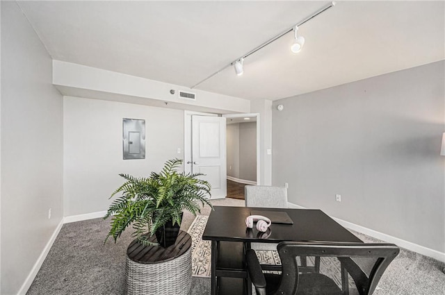 carpeted home office featuring electric panel and rail lighting