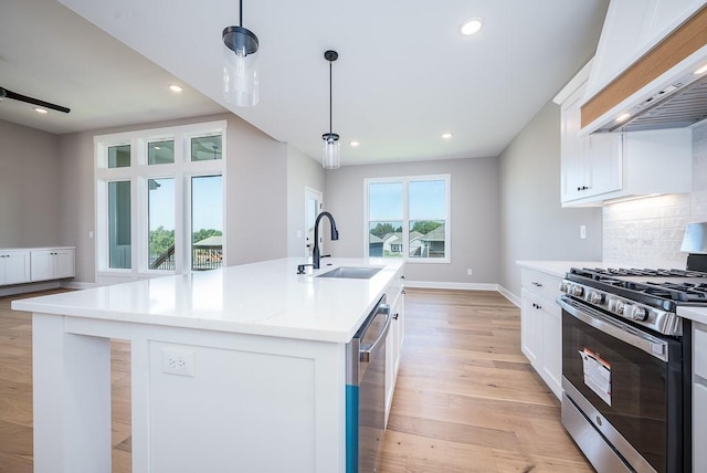 kitchen with white cabinetry, stainless steel appliances, custom range hood, and a center island with sink