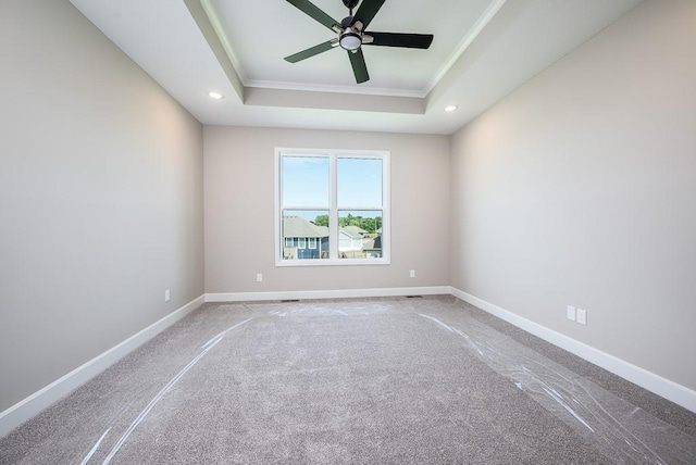 carpeted empty room with crown molding, ceiling fan, and a raised ceiling