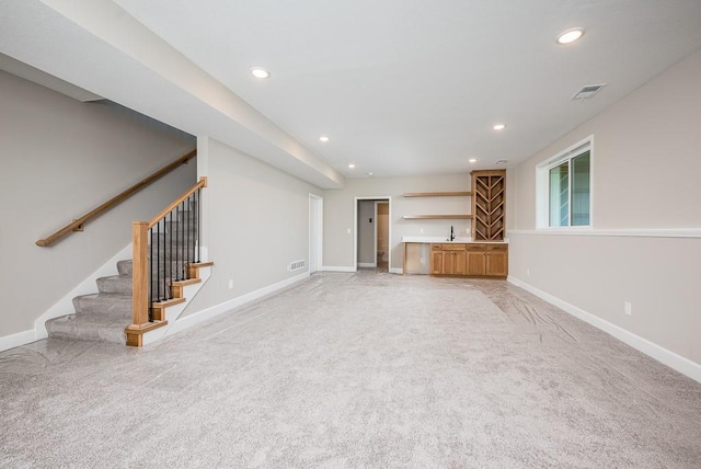 unfurnished living room with light carpet and wet bar