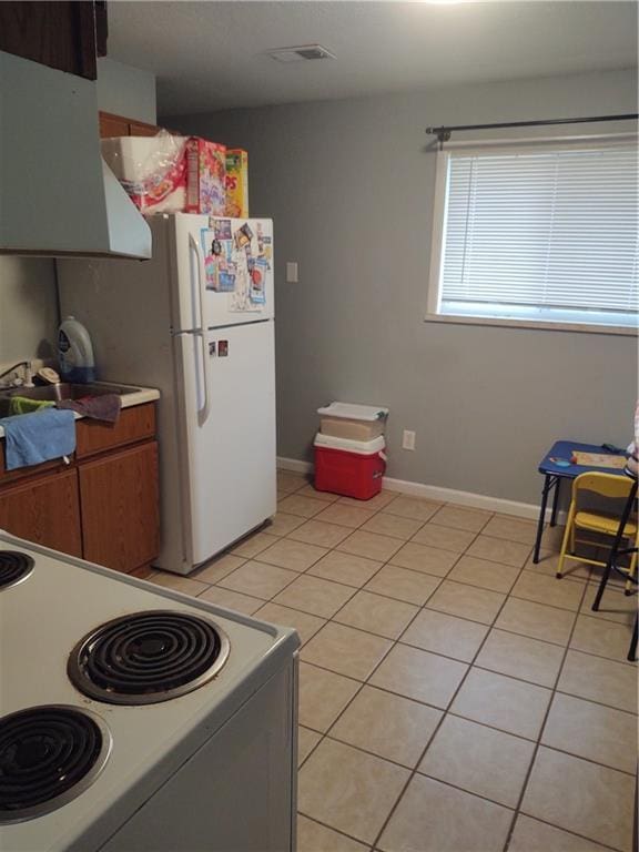 kitchen with white appliances, sink, and light tile patterned floors