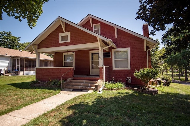 view of front of home featuring a porch, a sunroom, and a front lawn