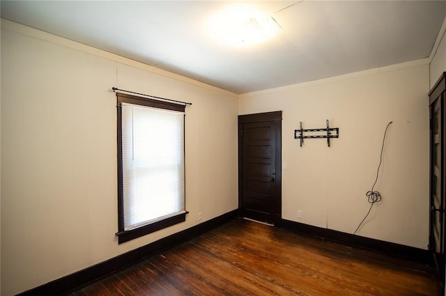 empty room featuring crown molding and dark hardwood / wood-style floors