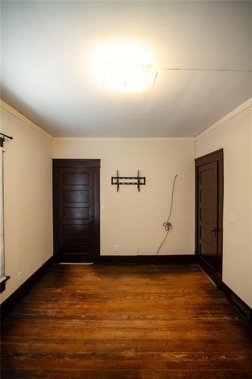 interior space featuring dark wood-type flooring and ornamental molding