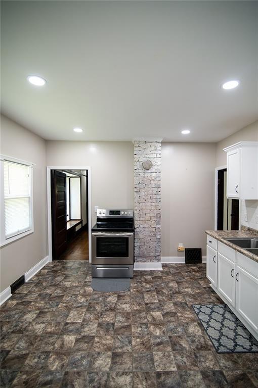 kitchen with sink, white cabinets, and stainless steel electric range