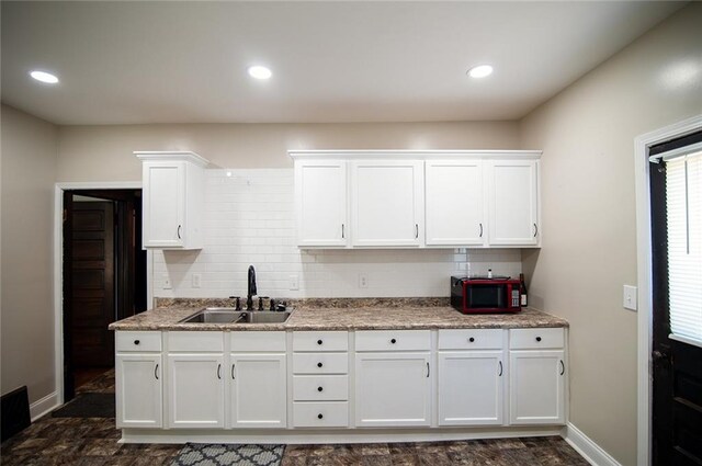 kitchen featuring sink, backsplash, and white cabinets